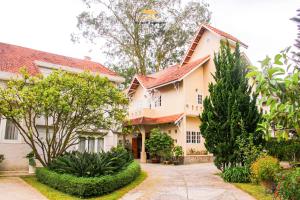 a house with trees and bushes in front of it at Nice Dream Villas in Da Lat