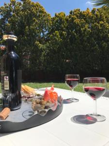 two glasses of wine and a plate of food on a table at Royal Suite in Tissi