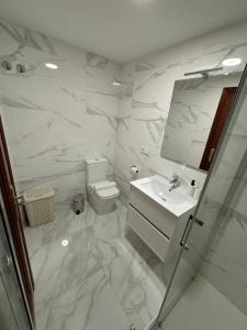 a bathroom with a toilet and a sink and a mirror at Apartamento Barbanza Arousa in Boiro +30 photos