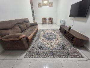 a living room with a couch and a rug at TheRapy House in Gua Sai
