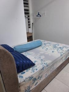 a bed with a blue and white blanket on it at TheRapy House in Malacca
