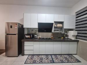 a kitchen with a refrigerator and a counter top at TheRapy House in Malacca