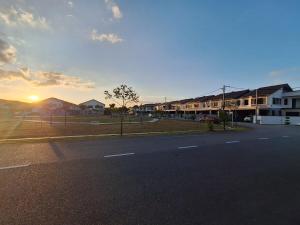 an empty street with houses and the sunset in the background at TheRapy House in Malacca