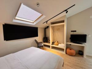 a bedroom with a bed and a flat screen tv at NisUrla in Urla