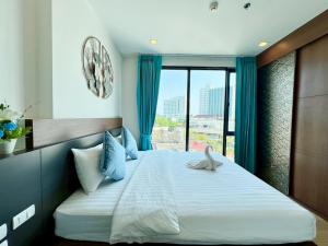 a bedroom with a bed with blue curtains and a window at THE ASTRA CONDO 2 BEDROOMS BY PING in Chiang Mai +101 photos