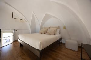 a bedroom with a white bed with an arched ceiling at Fronte Mare Casa Daspa in Gallipoli