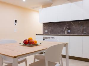 a kitchen with a wooden table with a bowl of fruit on it at Residenza Dante Luxury Apartment nel Centro Storico in Asolo