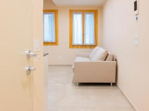 a living room with a white couch and windows at Residenza Dante Luxury Apartment nel Centro Storico in Asolo +23 photos