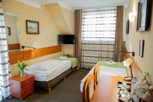 een hotelkamer met twee bedden en een tafel bij Motel Arkadia in Koszalin