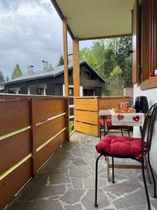 a patio with a table and two chairs on a porch at Il Giardino sull'Antelao in Masariè