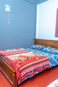 ein Bett mit einer bunten Decke darüber in der Unterkunft WWPVNE Winter Wood Private Villa Nuwara Eliya in Nuwara Eliya + 46 Fotos