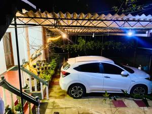 ein weißes Auto, das nachts in einer Garage parkt in der Unterkunft WWPVNE Winter Wood Private Villa Nuwara Eliya in Nuwara Eliya