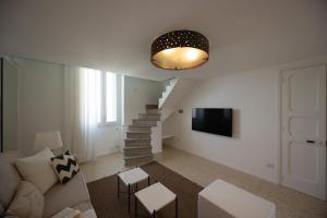 a living room with a staircase and a couch and a television at Fronte Mare Casa Daspa in Gallipoli
