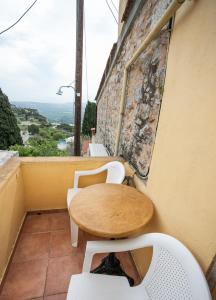 a table and chairs on the balcony of a building at Nefeli House Agios Georgios Sykousis Chios in Chios