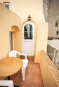 a patio with a table and a white door at Nefeli House Agios Georgios Sykousis Chios in Chios