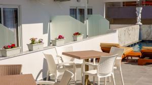 a patio with tables and chairs and a pool at Hotel Perla Ksamil in Ksamil