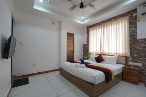 a bedroom with a large bed and a television at Pool View Resort in Cochin