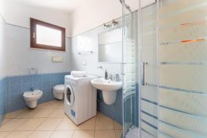 Un baño con lavabo, inodoro y ducha. en South Sardinia Holidays, en Domus de Maria