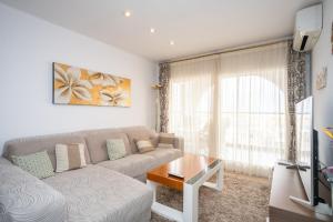 a living room with a couch and a table at Apartamentos Mila in Empuriabrava
