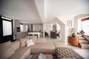 a living room with a large couch and a living room with at Large Open Plan Cottage with Balcony BBQ Area in Calstock