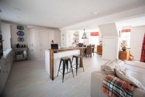 a kitchen and living room with a table and chairs at Large Open Plan Cottage with Balcony BBQ Area in Calstock