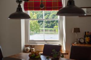 a kitchen with a window with a view of a lake at Large Open Plan Cottage with Balcony BBQ Area in Calstock +25 photos
