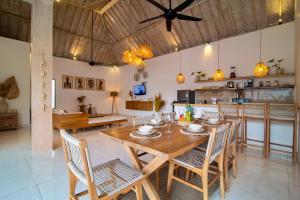 a dining room and kitchen with a wooden table and chairs at Simple & Magical Villas PRAYA in Seminyak