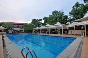 a large swimming pool with chairs and umbrellas at Enrise by Sayaji Bhopal in Bhopal