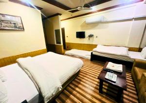 Postel nebo postele na pokoji v ubytování New Islamabad Hotel