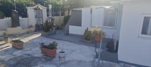 a courtyard with potted plants and a fence at Μονοκατοικία Σαλαμίνα in Áyios Yeóryios +1 photo