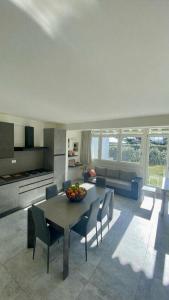 eine Küche und ein Wohnzimmer mit Tisch und Stühlen in der Unterkunft Ciliegio in Rosolina