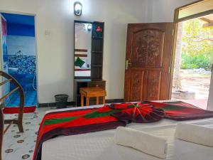 a bedroom with a bed with a colorful blanket on it at Sigiriya Moon Mirage Villa in Sigiriya