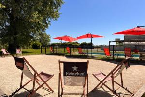 a group of chairs and umbrellas in a park at La Gravière in Fontenay-Trésigny