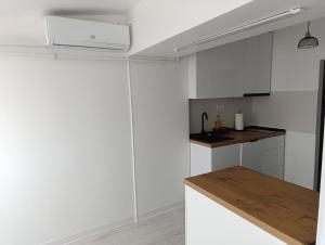a white kitchen with a counter and a sink at Central I in Târgu Jiu