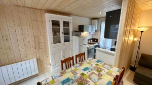 una pequeña cocina con una mesa y una cocina gmaxwell gmaxwell gmaxwell gmaxwell gmaxwell en Les Myrtilles Le Mont Dore 6pers, en Le Mont-Dore