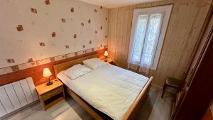 1 dormitorio con 1 cama, 2 mesas y una ventana en Les Myrtilles Le Mont Dore 6pers, en Le Mont-Dore