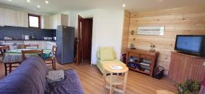 a living room with a couch and a tv and a kitchen at Chalet Roche Rousse in Gresse-en-Vercors