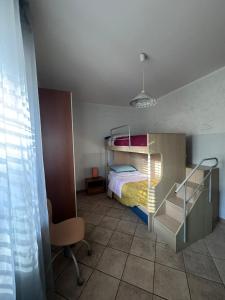 a small bedroom with a bunk bed and a chair at Villetta Indipendente fra i pini della Sila CS in Cosentino