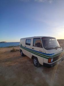 un furgone bianco parcheggiato sulla spiaggia vicino all'oceano di Camper Van vintage for drive with full equipment Mallorca a Sol de Mallorca