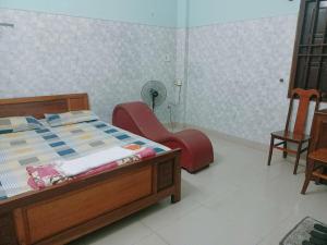1 dormitorio con 1 cama, ventilador y sillas en Nhân ái, en Da Nang