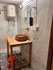 a bathroom with a wooden table and a sink at The Cozy Cabin, Jibhi in Banjār