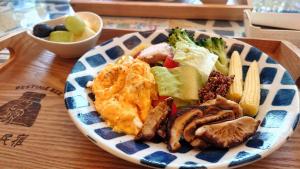 a blue and white plate of food on a table at Bestime B&B in Jiji