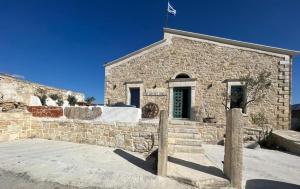 ein Steingebäude mit einer Flagge darüber in der Unterkunft The artist House Agio Farago in Pitsidia