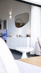 a room with a white table and a mirror at Le Loft Bleu in Petite Île +19 photos