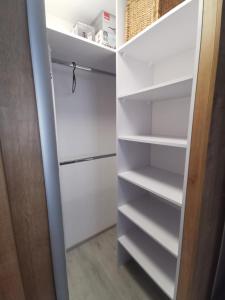 a closet with white shelves and a door at MATADOR apartment & Free Parking in Bratislava +18 photos