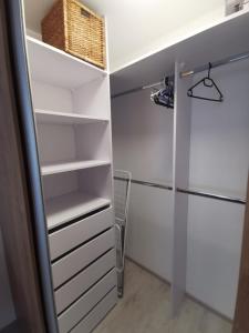 a walk in closet with white shelves and a basket at MATADOR apartment & Free Parking in Bratislava