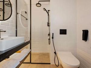 um banheiro com chuveiro, vaso sanitário e pia em Ibis World Trade Centre no Dubai