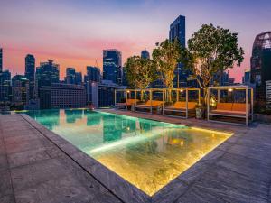 シンガポールにあるMondrian Singapore Duxtonの市街のスカイラインを背景にしたスイミングプール