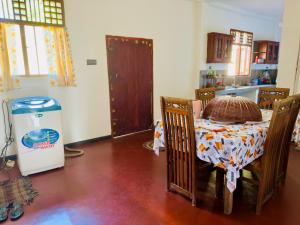 a dining room with a table and a refrigerator at Last Will Hill Top House in Weligama +3 photos