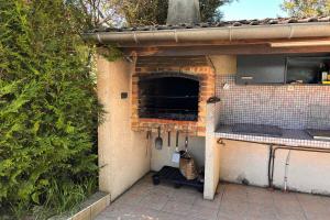 an outdoor kitchen with a counter and a oven at La Gravière in Fontenay-Trésigny +65 photos